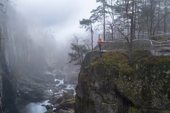 Ei kvinne står og ser utover elv og juv fra et utsiktspunkt.