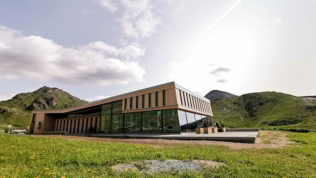 Large wooden building with a glass facade.