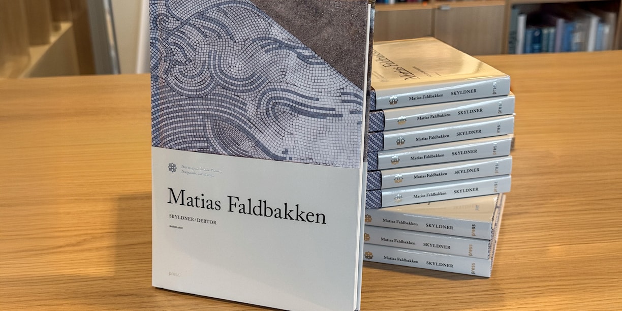 New art book presented in front of several art books stacked on top of each other.