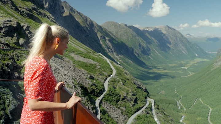 Ei kvinne nyt utsikta frå eit utsiktspunkt i Trollstigen.