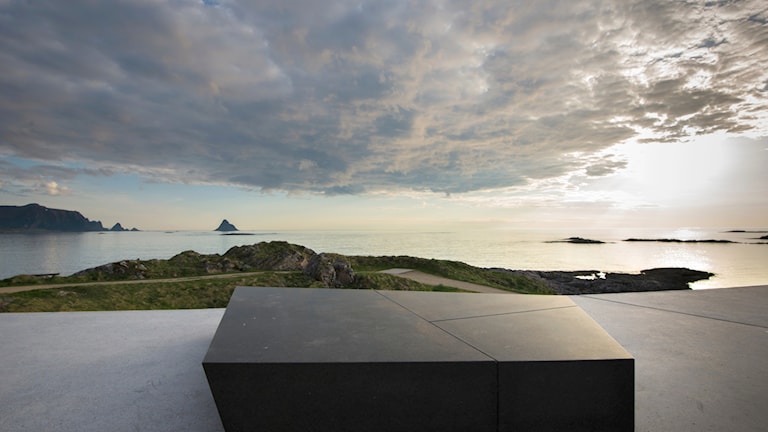 Kleivodden rasteplass med utsyn mot havet, sola bryter gjennom skyene.