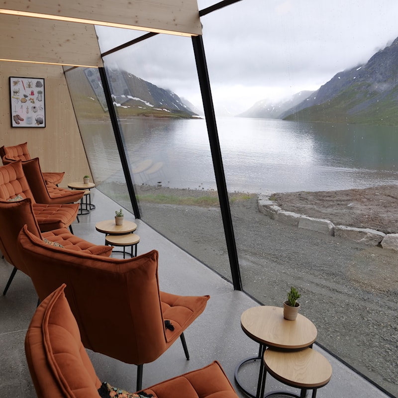 Hvilestoler i kafeen med utsikt til innsjøen Gjende og fjellene.